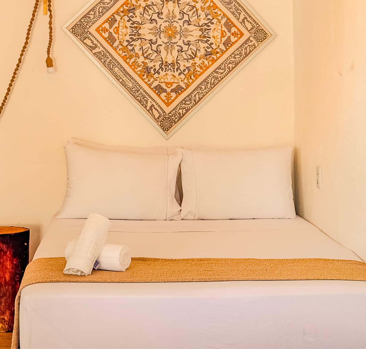 Cabeceira da cama da Suíte Sertão com painel indiano emoldurado e enxoval branco