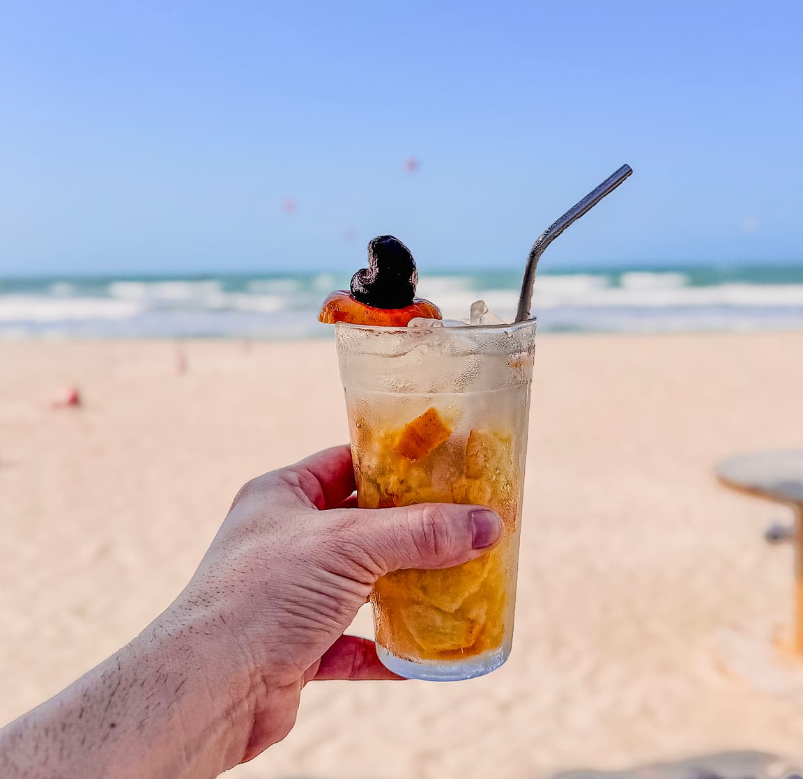 Coquetel gelado na praia do Preá com pipas de kitesurf ao fundo