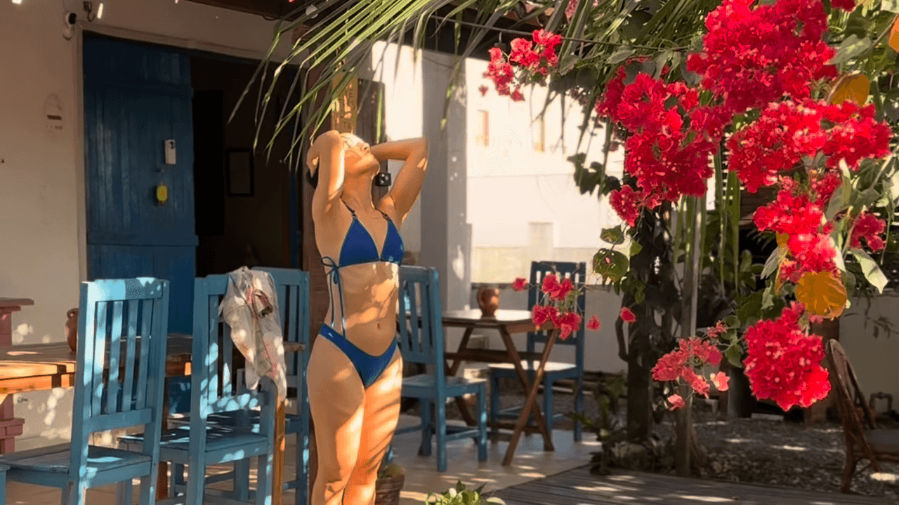 Hóspede na área externa da Casa Mareser, cercada por bougainvillea vermelha